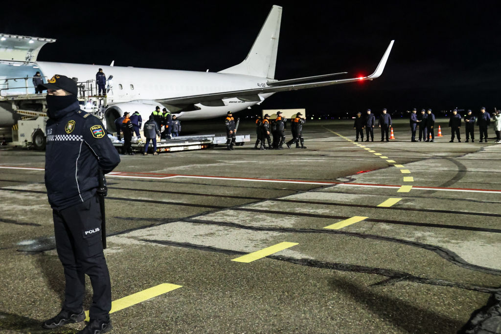 Workers carry the coffin of a victim after the Azerbaijan Airlines crash. (Aziz Karimov/Getty Images)