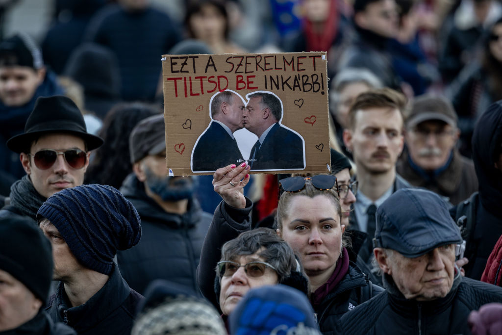 A demonstrator holds a banner that shows Hungary Prime Minister Viktor Orbán and Russian President Vladimir Putin as protesters demonstrated against a new law banning Budapest's annual Pride march. (Janos Kummer/Getty Images)