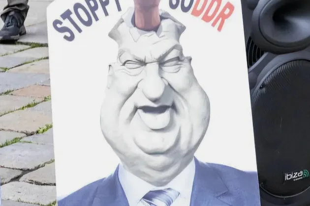A 67-year-old retired Bavarian woman was found guilty of insulting a public official and must pay an €800 fine for displaying a caricature of Markus Söder during a protest against COVID-19 policies. ( source private)
